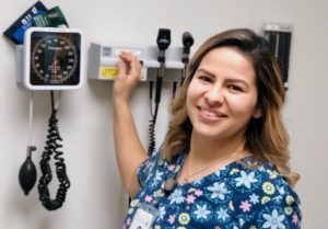 Maribel Antovski headshot in front of examining room medical instruments